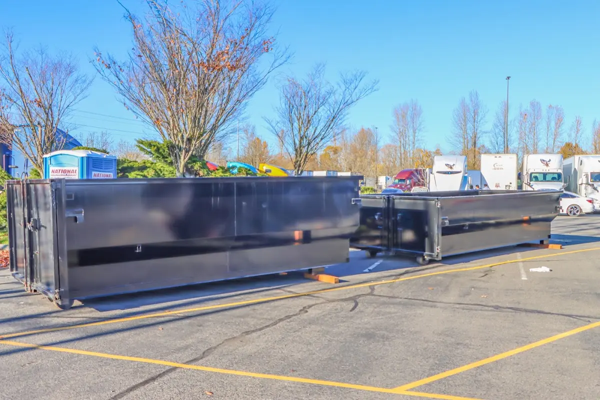 Professional dumpster rental service with roll-off container on residential driveway in Emmett